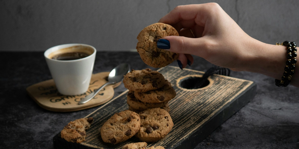 Femme dégustant un biscuit artisanal devant une tasse de café